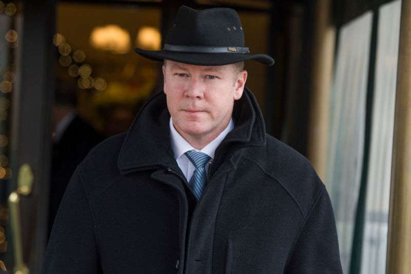 A serious man in a heavy coat and hat.