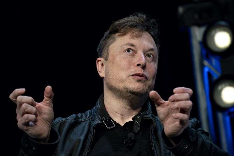 SpaceX CEO Elon Musk gesturing with his hands and speaking during a conference.