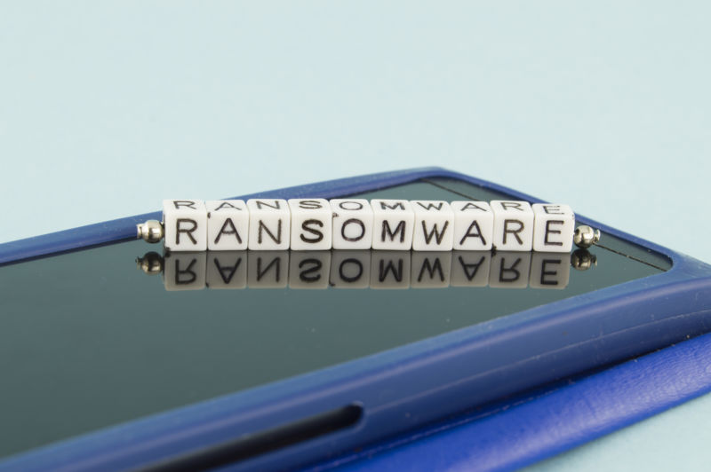 Scrabble letters sitting atop laptop computer spell Ransomware.